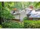 Stylish home exterior surrounded by lush greenery, showcasing unique architecture and a serene, wooded setting at 1604 Pinecrest Rd, Durham, NC 27705