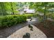Landscaped pathway to a beautiful home nestled in mature trees at 1604 Pinecrest Rd, Durham, NC 27705