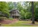 Back exterior view of home with unique architecture, surrounded by mature hardwood trees at 1604 Pinecrest Rd, Durham, NC 27705