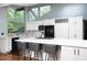 Modern kitchen with white cabinetry, a center island with seating, and sleek black appliances at 1604 Pinecrest Rd, Durham, NC 27705