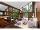 Open living room with floor to ceiling windows, vaulted ceilings and rich wood paneling, creating a warm and spacious atmosphere at 1604 Pinecrest Rd, Durham, NC 27705