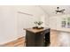Bright living room featuring wood-look floors, a ceiling fan, and a dark kitchen island with butcher block top at 17 Crystal Oaks Ct, Durham, NC 27707