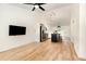 A well-lit living room with a ceiling fan, open to a modern kitchen, and light wood floors at 17 Crystal Oaks Ct, Durham, NC 27707