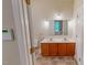 Bright bathroom features a double sink vanity with oak cabinets and tiled floors at 20 Banbury Ct, Roxboro, NC 27573