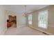 Traditional dining room with neutral color palette, chandelier, and view into the living room with brick fireplace at 20 Banbury Ct, Roxboro, NC 27573