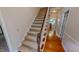 Carpeted staircase with wooden banister, connecting different levels of the home with a view of the dining area at 20 Banbury Ct, Roxboro, NC 27573