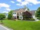 Charming two-story home with a brick facade, manicured lawn, mature trees, and well-maintained landscaping at 2000 Katesbridge Ln, Raleigh, NC 27614