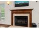 Close up on the fireplace with a decorative mantle, marble surround, and wall-mounted TV at 2000 Katesbridge Ln, Raleigh, NC 27614
