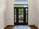 Bright foyer featuring a stylish black door, transom window, and hardwood floors with a colorful rug at 2000 Katesbridge Ln, Raleigh, NC 27614