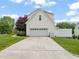 Attached garage with driveway and manicured front yard with mature landscaping at 2000 Katesbridge Ln, Raleigh, NC 27614