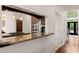 Kitchen with granite countertops, stainless steel appliances, dark wood cabinets, and views into the dining area at 2000 Katesbridge Ln, Raleigh, NC 27614