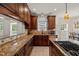 Kitchen features granite countertops, dark wood cabinets, and an island with cooktop at 2000 Katesbridge Ln, Raleigh, NC 27614