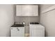 Well-lit laundry room with white appliances, upper cabinets, and ample space for laundry tasks at 2000 Katesbridge Ln, Raleigh, NC 27614