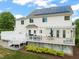 Back exterior view of a two-story home with a deck, white siding, and solar panels on the roof at 2000 Katesbridge Ln, Raleigh, NC 27614