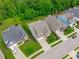 An aerial view of neighborhood houses with manicured lawns and tree lined street on a sunny day at 2036 Amy Grace Ct, Fuquay Varina, NC 27526
