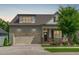 Charming home featuring a two-car garage, front porch with chairs, and beautiful landscaping at 2036 Amy Grace Ct, Fuquay Varina, NC 27526