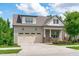Charming home featuring a two-car garage, front porch with chairs, and beautiful landscaping at 2036 Amy Grace Ct, Fuquay Varina, NC 27526