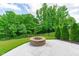 Backyard featuring an outdoor stone fire pit area with lush greenery in background at 2036 Amy Grace Ct, Fuquay Varina, NC 27526