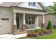 Inviting front porch with stone accents, seating, and colorful flower beds at 2036 Amy Grace Ct, Fuquay Varina, NC 27526