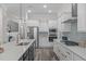 Modern kitchen featuring white cabinets, stainless steel appliances, and gray backsplash at 2036 Amy Grace Ct, Fuquay Varina, NC 27526