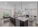 Kitchen island with a sink overlooking the living room, dining room, and sliding doors to the outdoor deck at 2036 Amy Grace Ct, Fuquay Varina, NC 27526