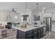 Open concept kitchen island featuring white countertop, sink, and a view into the living room with a fireplace at 2036 Amy Grace Ct, Fuquay Varina, NC 27526