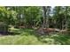 Lush backyard with mature trees, a well-maintained lawn, and a seating area, perfect for outdoor activities at 205 Benwell Ct, Cary, NC 27519