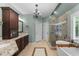 Large bathroom featuring a soaking tub, glass shower, chandelier, and dual vanities at 205 Benwell Ct, Cary, NC 27519