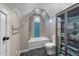 Well-lit bathroom featuring blue accent tiles, a glass shower, and a unique cabinet at 205 Benwell Ct, Cary, NC 27519