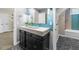 A modern bathroom showcasing tiled accents, a sleek black vanity, and a glass-enclosed shower and tub at 205 Benwell Ct, Cary, NC 27519