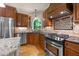 Gourmet kitchen features custom cabinets, granite countertops, stainless steel appliances, and a large window for natural light at 205 Benwell Ct, Cary, NC 27519