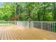 Large wooden deck with white railings offering a peaceful view of the surrounding lush greenery at 214 Wax Myrtle Ct, Cary, NC 27513