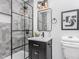 Modern bathroom with glass enclosed shower, black vanity, square mirror, and chic lighting fixtures at 2205 W Carver St, Durham, NC 27705