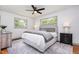 Spacious bedroom featuring a ceiling fan, two large windows, and neutral decor at 2205 W Carver St, Durham, NC 27705