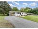 View of the well-maintained home with a carport and gravel driveway at 2205 W Carver St, Durham, NC 27705