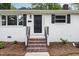 Inviting front entrance featuring a black door, brick stairs, and manicured landscaping at 2205 W Carver St, Durham, NC 27705