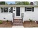 Inviting front entrance with brick steps and black door and shutters at 2205 W Carver St, Durham, NC 27705