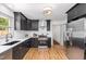 Well-lit kitchen features stainless steel appliances, black cabinets, subway tile backsplash, and stylish hardware at 2205 W Carver St, Durham, NC 27705