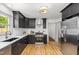 Modern kitchen featuring black cabinetry, stainless steel appliances, and white countertops at 2205 W Carver St, Durham, NC 27705