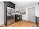 Laundry room with stainless steel refrigerator, black washer/dryer, and a window for natural light at 2205 W Carver St, Durham, NC 27705