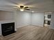 Bright living room with wood-look flooring, fireplace, built-in shelving, and view into the kitchen at 225 Virens Drive, Cary, NC 27511