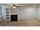 Spacious living room with fireplace, built-in shelving, ceiling fan, and wood-look flooring at 225 Virens Drive, Cary, NC 27511