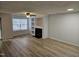 Spacious living room with wood-look flooring, fireplace, built-in shelving, and window offering natural light at 225 Virens Drive, Cary, NC 27511