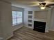 Cozy living room with wood-look floors, fireplace, built-in shelving, and a window offering natural light at 225 Virens Drive, Cary, NC 27511