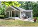 Side view of house showcasing a patio, string lights, mature trees, and lush green grass at 2409 New Hope Church Rd, Chapel Hill, NC 27514