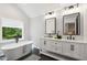 Bright bathroom featuring a freestanding tub, double sink vanity, and black hardware at 2409 New Hope Church Rd, Chapel Hill, NC 27514