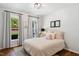 Cozy bedroom featuring a light pink comforter, hardwood floors, and two windows at 2409 New Hope Church Rd, Chapel Hill, NC 27514