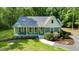 Charming home featuring a welcoming front porch, beautifully landscaped front yard, and a serene wooded backdrop at 2409 New Hope Church Rd, Chapel Hill, NC 27514