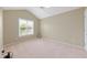 Empty bedroom featuring neutral walls, beige carpet, and a window for natural light at 2420 Sapphire Valley Dr, Raleigh, NC 27604