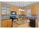 Kitchen with a center island, mosaic backsplash, and light wood cabinetry at 2420 Sapphire Valley Dr, Raleigh, NC 27604